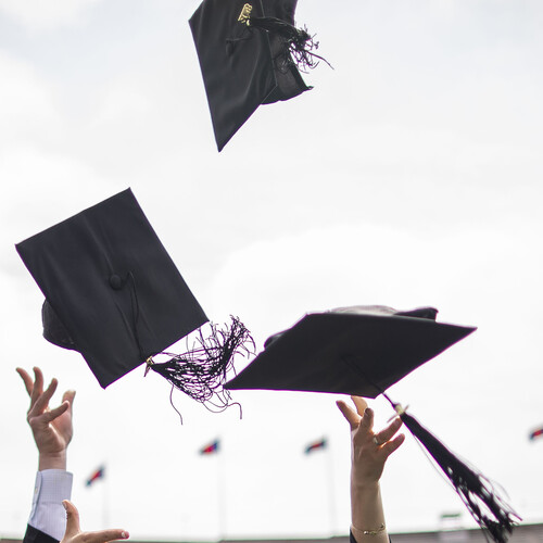 Graduation caps thrown in air