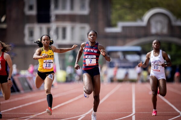 Runners running on the track at Franklin Field during the Penn Relays.