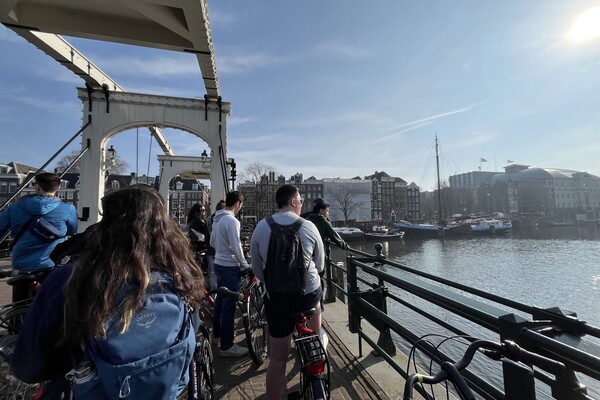 Penn students riding bikes over a bridge in Amsterdam.
